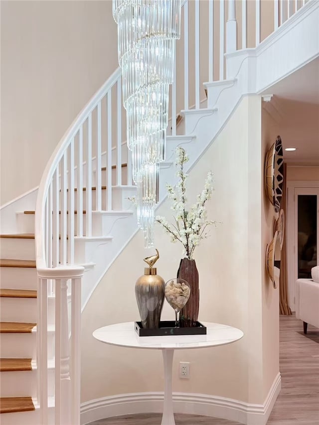 staircase with a healthy amount of sunlight, a high ceiling, and wood finished floors