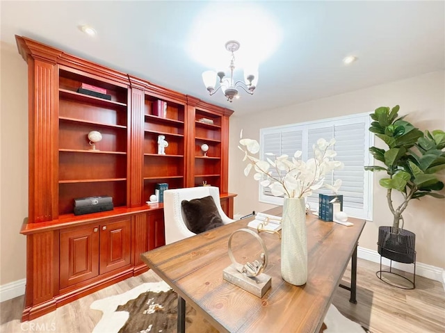 office area featuring baseboards, a notable chandelier, and light wood-style floors