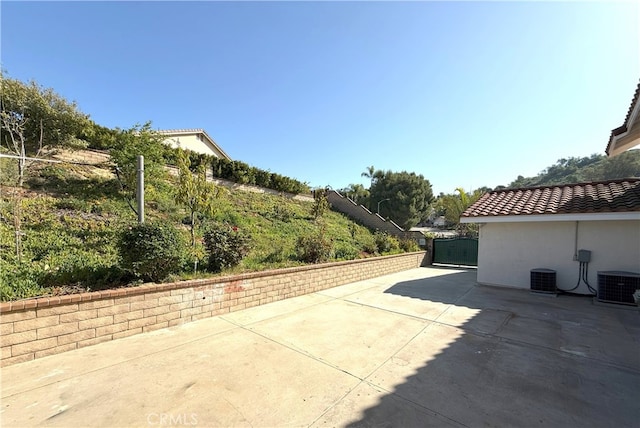 view of property exterior with a tiled roof, stucco siding, central AC unit, and fence