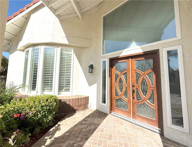 doorway to property with a tiled roof and stucco siding