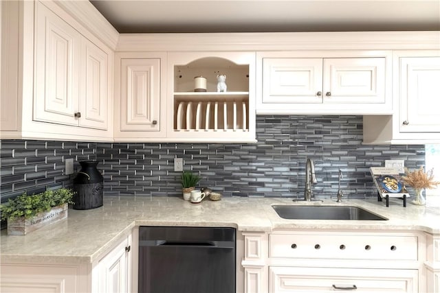 kitchen with dishwashing machine, white cabinetry, light stone counters, a sink, and decorative backsplash