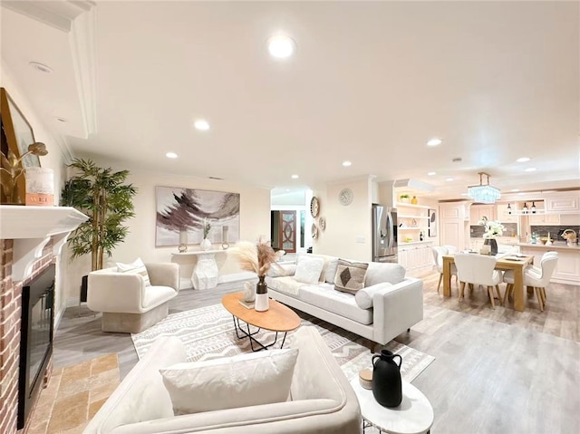 living room featuring light wood-type flooring, recessed lighting, and a fireplace