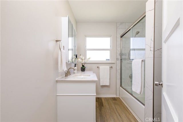 bathroom featuring combined bath / shower with glass door, vanity, and wood finished floors