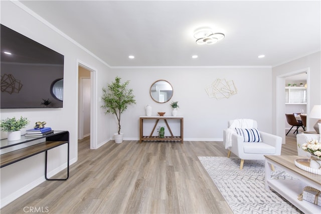 living area with wood finished floors, ornamental molding, and recessed lighting