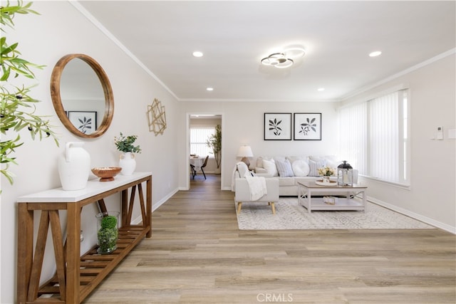 living room with crown molding, recessed lighting, baseboards, and light wood-style floors
