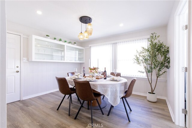 dining area with baseboards, a chandelier, and wood finished floors