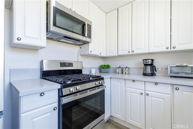kitchen with white cabinetry, light countertops, and appliances with stainless steel finishes