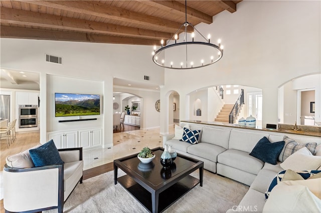 living area featuring high vaulted ceiling, arched walkways, visible vents, stairway, and wooden ceiling