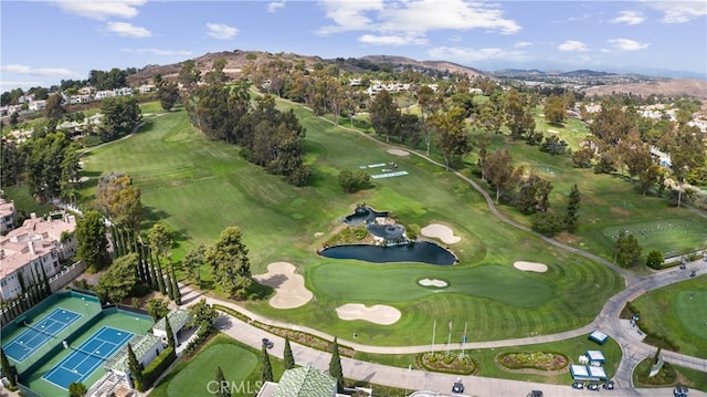 drone / aerial view featuring golf course view and a water and mountain view