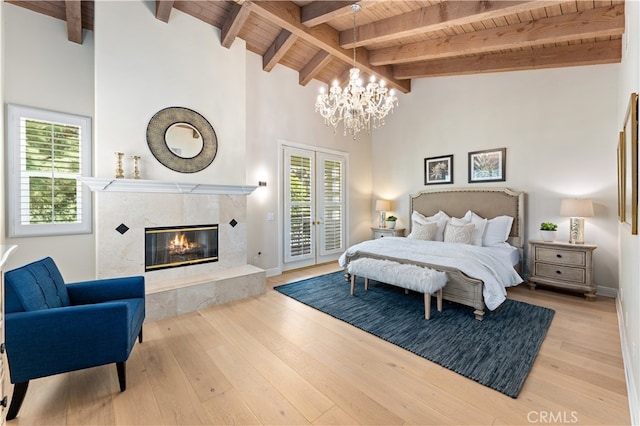 bedroom featuring beamed ceiling, multiple windows, access to exterior, and wooden ceiling