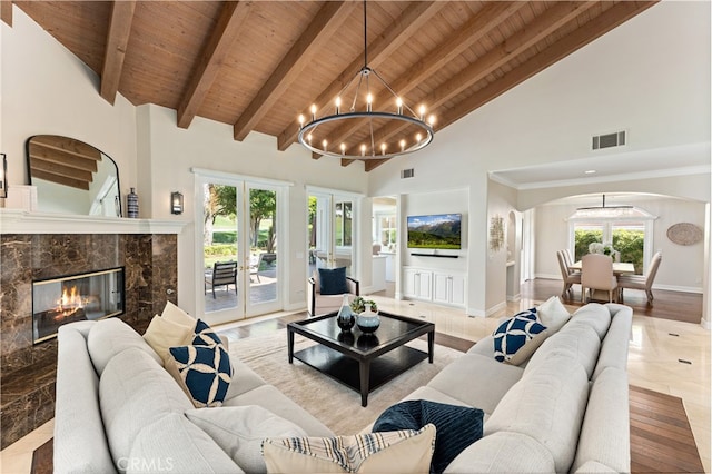 living area with an inviting chandelier, arched walkways, visible vents, and wooden ceiling