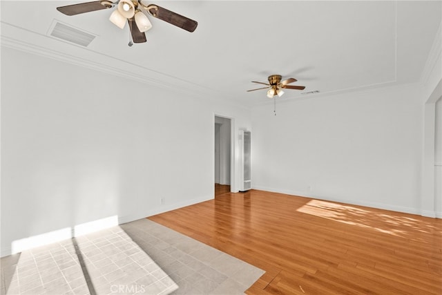 unfurnished room featuring crown molding, a ceiling fan, and visible vents