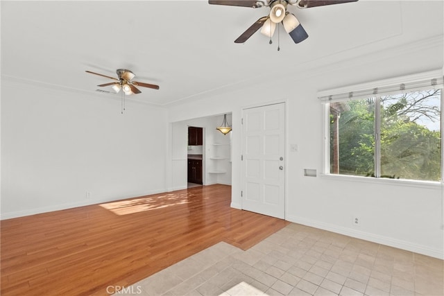 unfurnished room featuring light wood-type flooring, ornamental molding, baseboards, and a ceiling fan