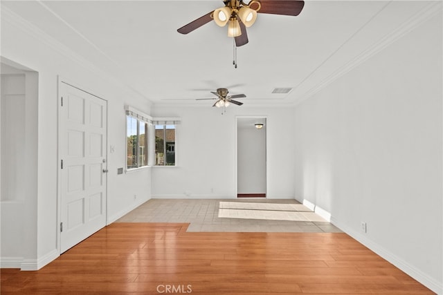 interior space featuring crown molding, wood finished floors, a ceiling fan, and visible vents