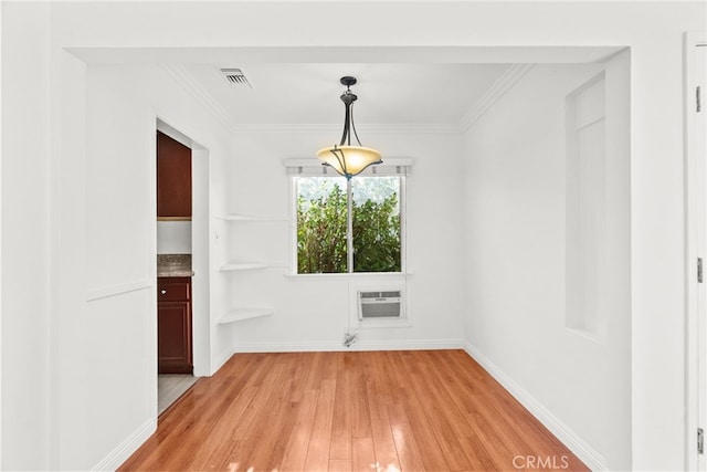 unfurnished dining area with crown molding, visible vents, an AC wall unit, light wood finished floors, and baseboards