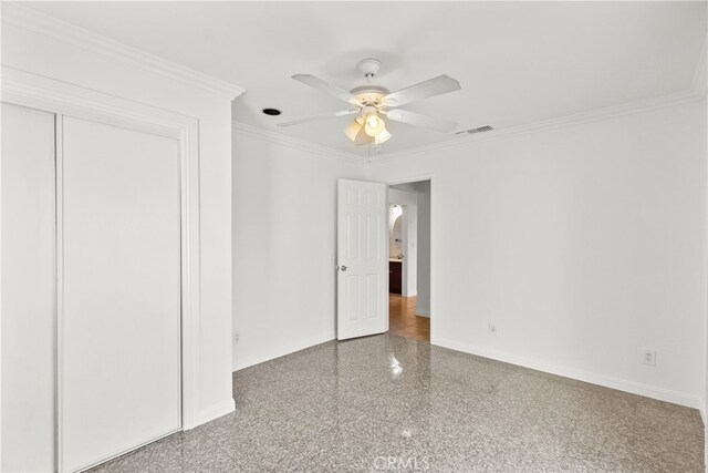 unfurnished bedroom with a closet, baseboards, granite finish floor, crown molding, and visible vents