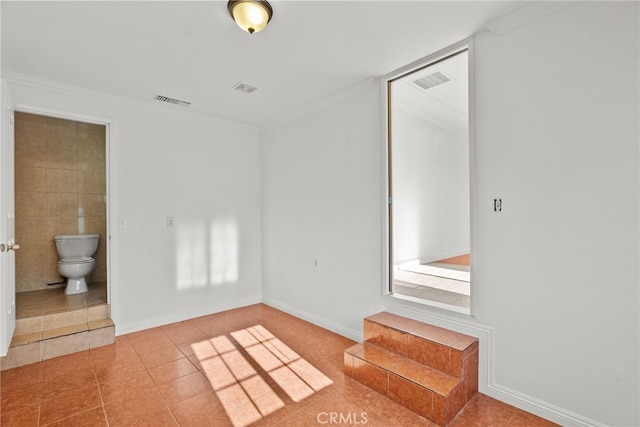 tiled spare room with crown molding, baseboards, and visible vents