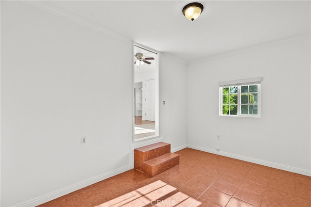 spare room with ornamental molding, baseboards, ceiling fan, and tile patterned floors