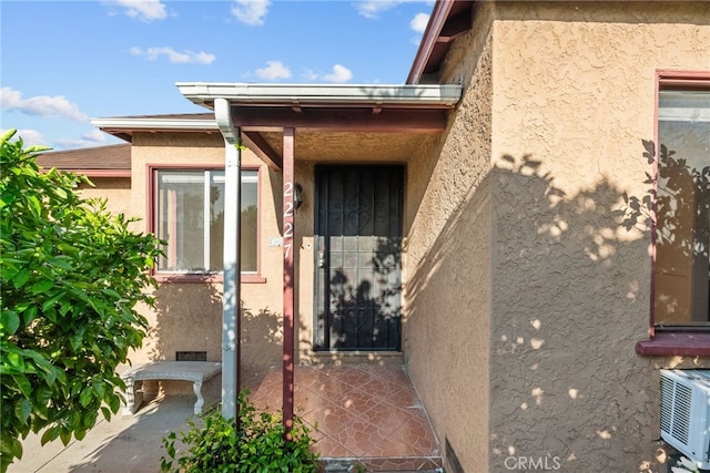 entrance to property featuring stucco siding