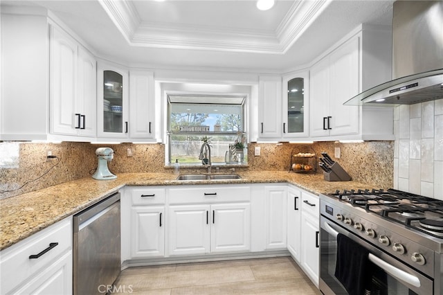 1212 Goldenview Dr, Corona, CA 92882 - kitchen featuring appliances with stainless steel finishes, wall chimney exhaust hood, a sink, a tray ceiling, and light stone countertops