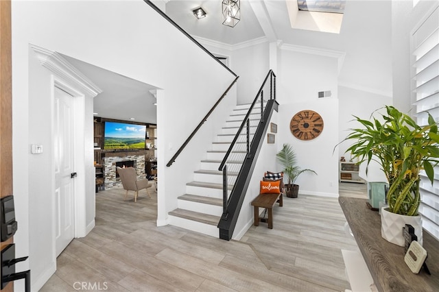 1212 Goldenview Dr, Corona, CA 92882 - staircase with a stone fireplace, wood finished floors, a high ceiling, baseboards, and a skylight