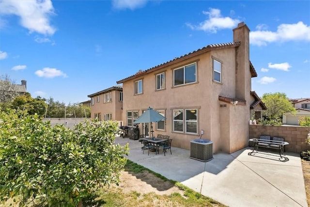 rear view of property with a patio, a chimney, stucco siding, and fence