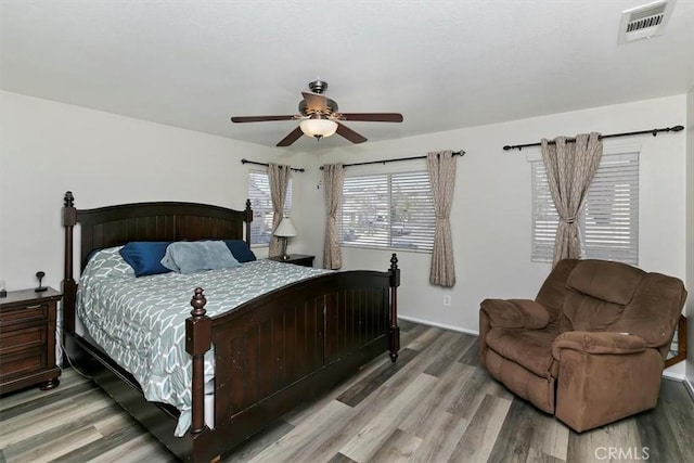 bedroom featuring wood finished floors, a ceiling fan, and visible vents