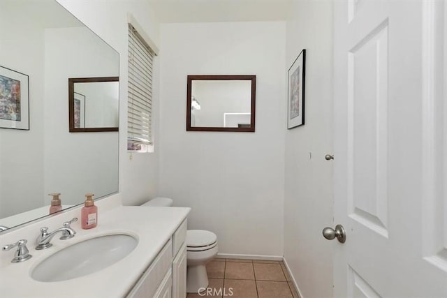 half bathroom featuring tile patterned floors, toilet, vanity, and baseboards
