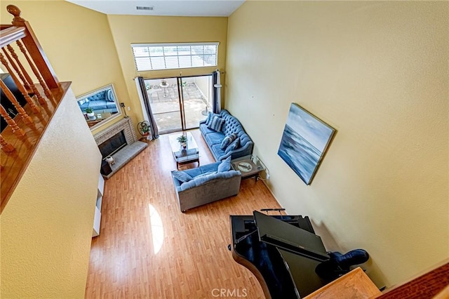 22933 Estoril Dr Unit 1, Diamond Bar, CA 91765 - living area with a glass covered fireplace, a towering ceiling, visible vents, and wood finished floors