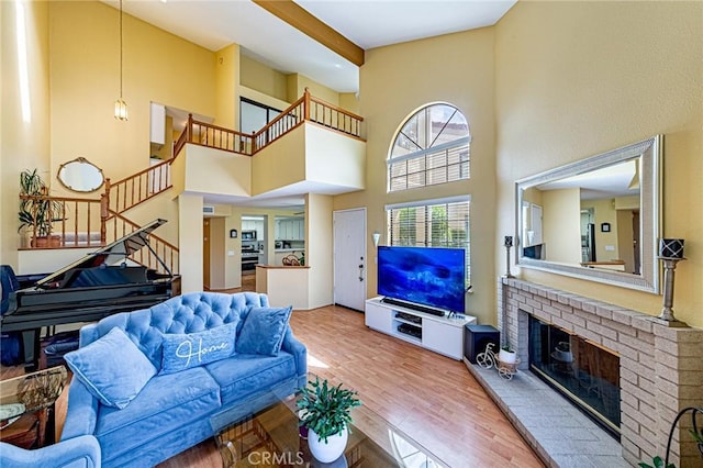 22933 Estoril Dr Unit 1, Diamond Bar, CA 91765 - living room featuring a high ceiling, stairway, wood finished floors, and a brick fireplace