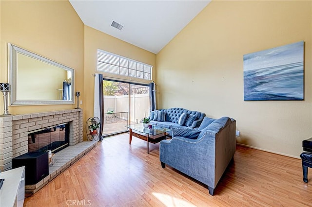 22933 Estoril Dr Unit 1, Diamond Bar, CA 91765 - living area featuring high vaulted ceiling, visible vents, light wood-type flooring, and a brick fireplace