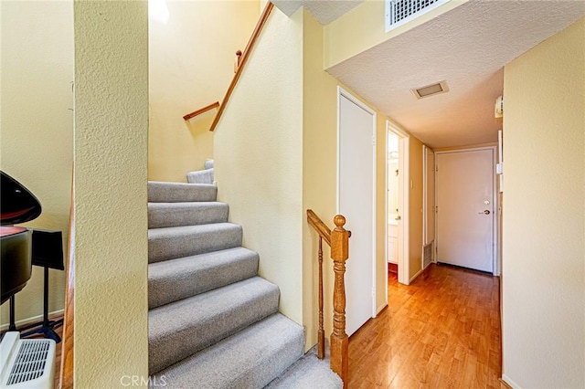 22933 Estoril Dr Unit 1, Diamond Bar, CA 91765 - stairway with visible vents, a textured ceiling, baseboards, and wood finished floors