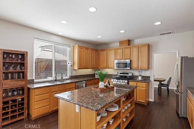 kitchen with visible vents, a center island, open shelves, a sink, and appliances with stainless steel finishes