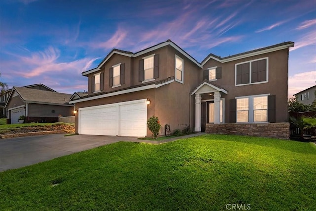 traditional-style home featuring a garage, stucco siding, driveway, and a front yard