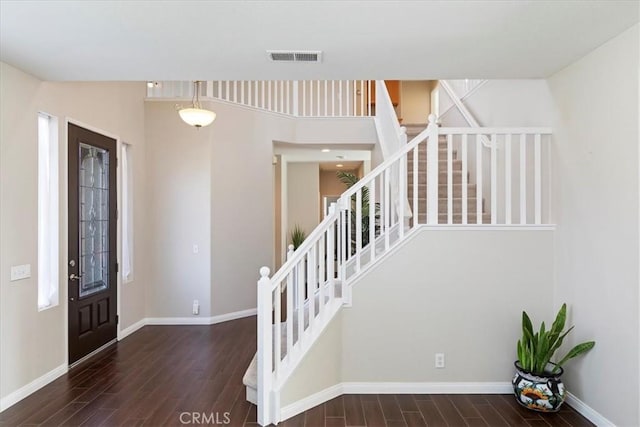 entrance foyer with stairs, baseboards, and wood finished floors