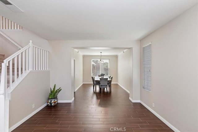 dining area with baseboards, dark wood finished floors, visible vents, and stairway