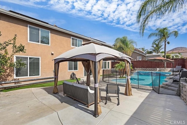 exterior space featuring a fenced in pool, a patio, an outdoor living space, a fenced backyard, and a gazebo