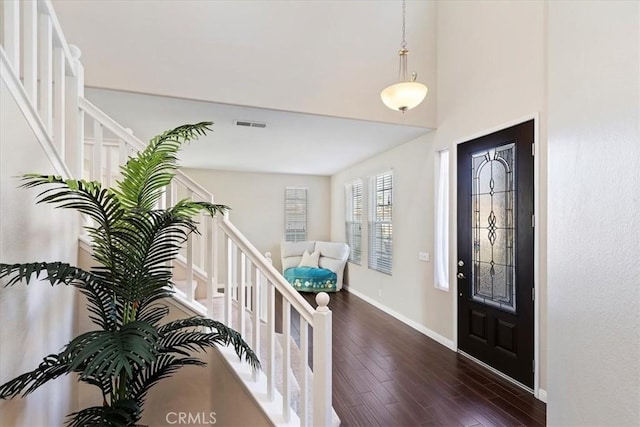 entrance foyer with visible vents, baseboards, stairway, and dark wood-style floors