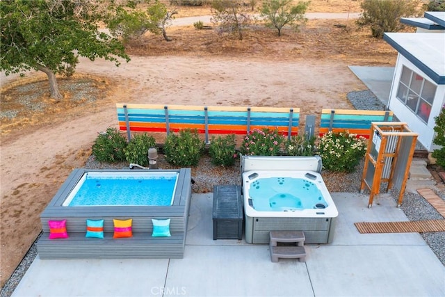 view of swimming pool with a patio area, fence, and a hot tub