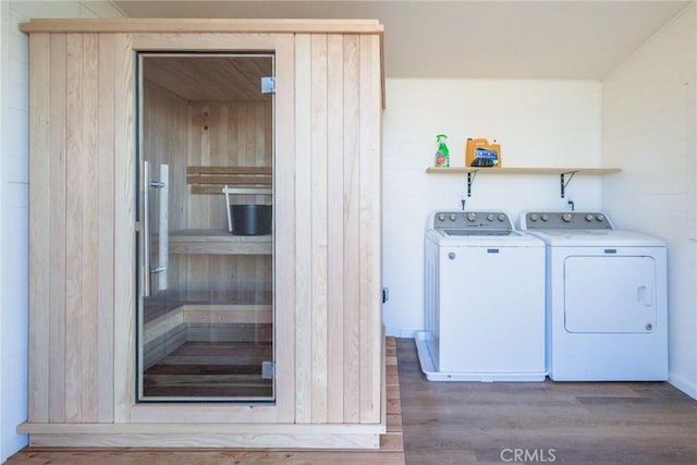 washroom featuring laundry area, wood finished floors, and washer and clothes dryer