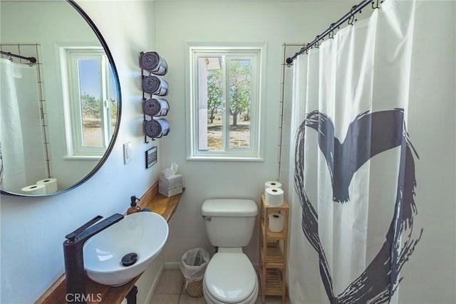 bathroom featuring tile patterned floors, a shower with shower curtain, a sink, and toilet