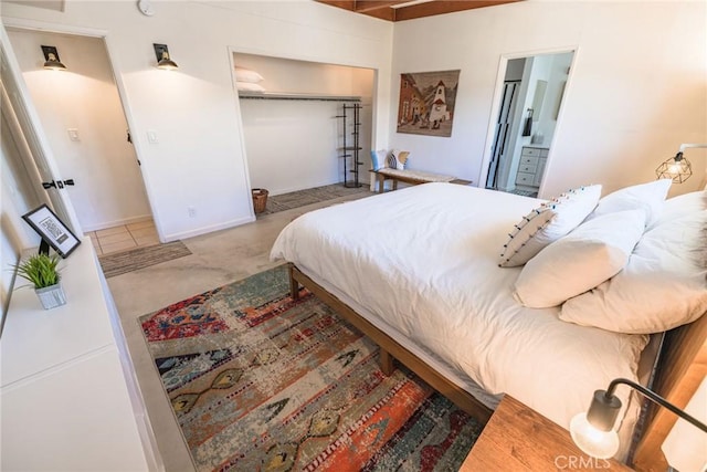 bedroom featuring a closet, carpet, and ensuite bathroom