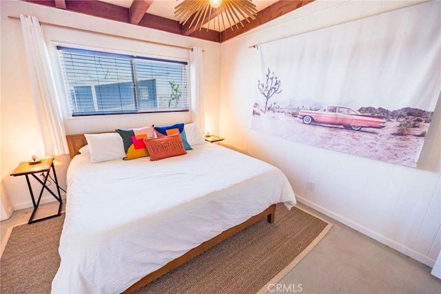 bedroom with baseboards, beamed ceiling, and carpet floors