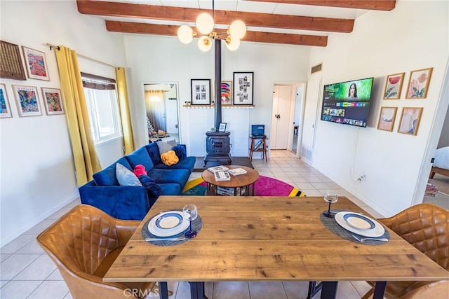 dining space featuring a wood stove, beamed ceiling, light tile patterned floors, visible vents, and baseboards
