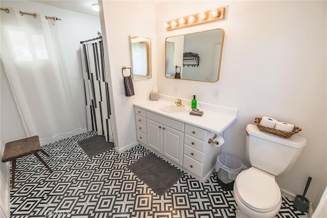 bathroom featuring vanity, baseboards, and toilet