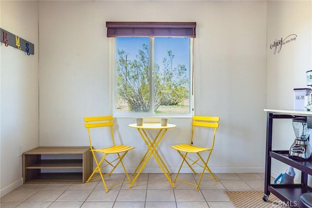sitting room featuring tile patterned floors, plenty of natural light, and baseboards