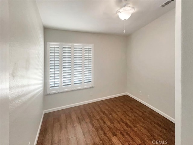 spare room featuring wood finished floors, baseboards, and visible vents