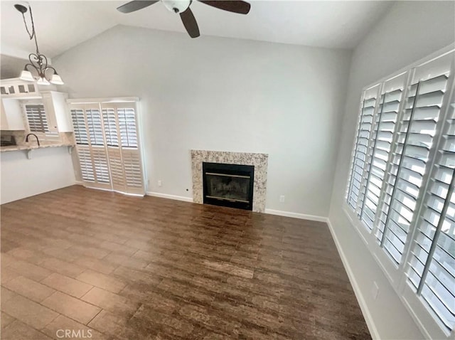 unfurnished living room with ceiling fan, a high end fireplace, and a healthy amount of sunlight