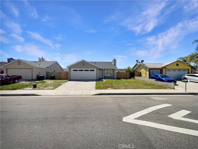 ranch-style home featuring concrete driveway, a front yard, fence, and an attached garage