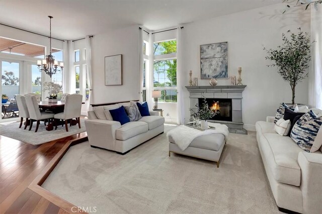 14043 Shepherd Dr, Rancho Cucamonga, CA 91739 - living room with a chandelier, plenty of natural light, hardwood / wood-style flooring, and a glass covered fireplace